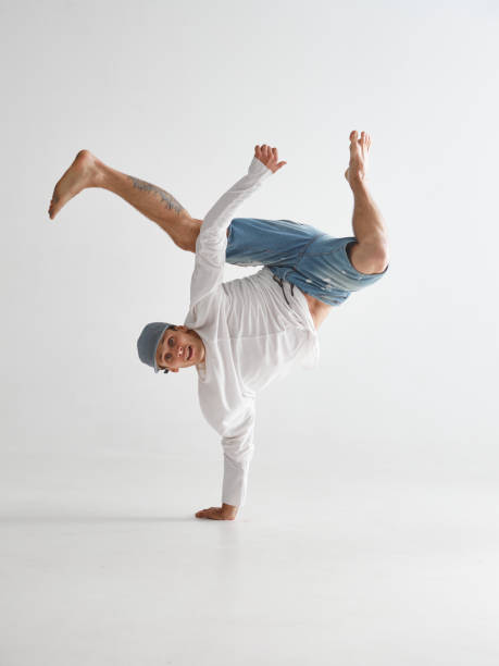 istock Young breakdancer stands on one arm dancing hip-hop isolated on white background. Break dance school poster 1265609243