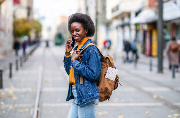 istock Cheerful female traveler using cell phone on the street. 1265609366