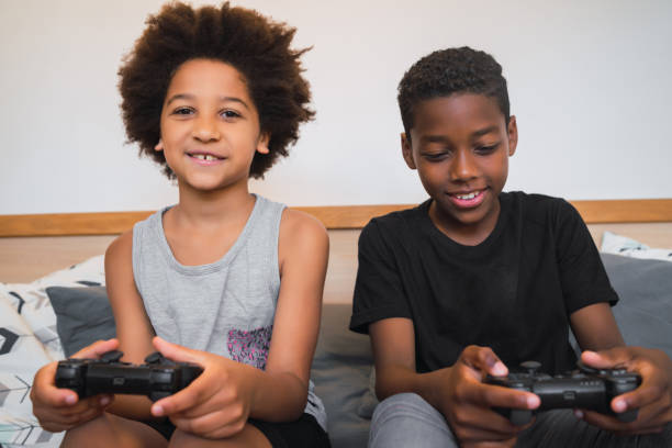 istock Two brothers playing video games at home. 1265610601