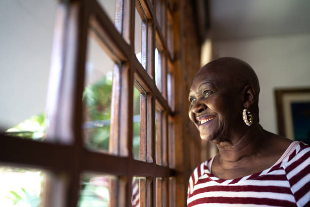 istock Senior woman contemplating, looking through the window 1265613661