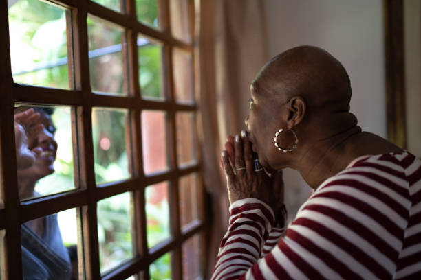 istock Visiting quarantined mother, communicating through a glass window 1265613771