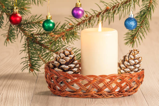 istock Burning candle, cones and natural fir tree branches with Christmas balls 1265614359