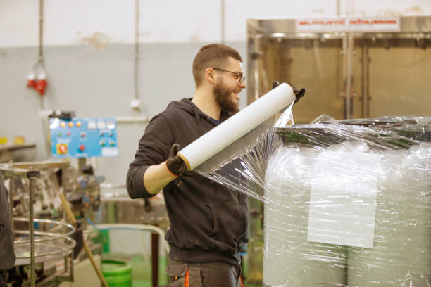 istock Brewery warehouse worker wrapping kegs up for distribution 1265618575