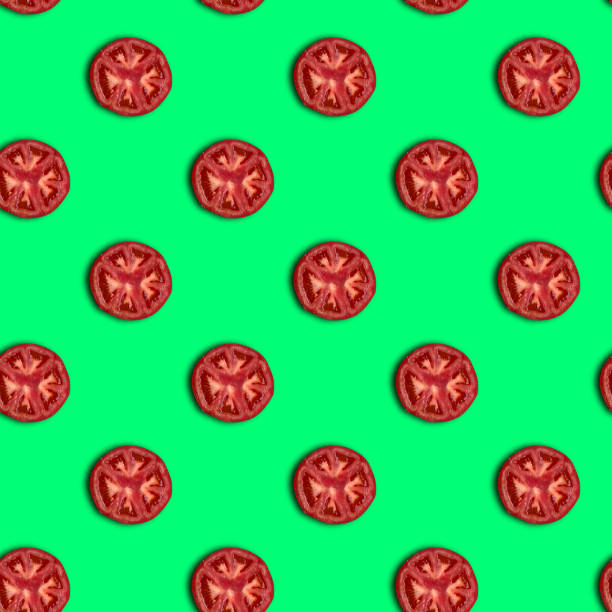 istock Seamless pattern. Isolated tomato slices on a green background 1265618601