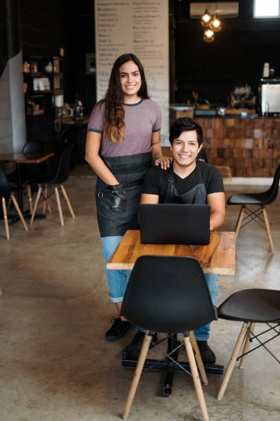 Happy owners of coffee shop smiling at camera