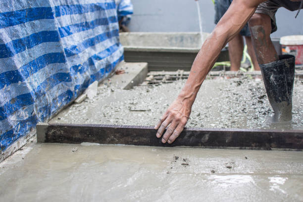 istock Leveling concrete with trowels, laborer spreading poured concrete 1265620699