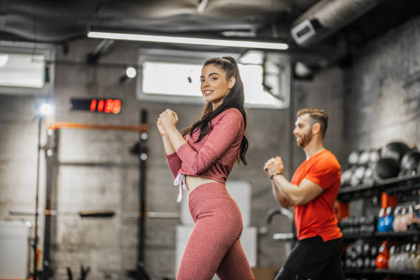 istock Young people doing lunges together during their workout in a gym 1265621292