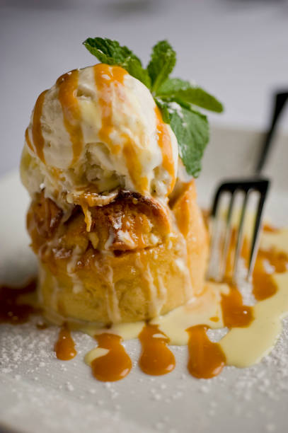 istock Bread pudding. Bread pudding with vanilla ice cream. Desserts. Classic American or French bakeries or pastry shop favorites. Cookies, whipped cream, cakes, chocolate syrup butter, eggs and vanilla beans. 1265627462