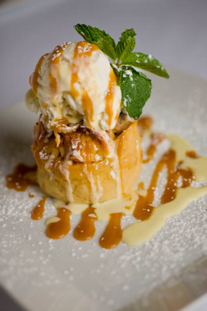 istock Bread pudding. Bread pudding with vanilla ice cream. Desserts. Classic American or French bakeries or pastry shop favorites. Cookies, whipped cream, cakes, chocolate syrup butter, eggs and vanilla beans. 1265627464