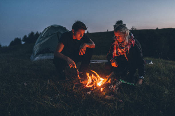 istock Couple camping in mountains at night under starry sky 1265632582