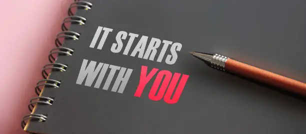 It Starts With You words printed in notebook and luxury pen. Self Motivation concept