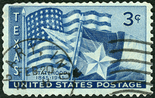 Postage stamp printed in USA shows US and Texas State Flags, Texas Statehood Centenary 1845, 1945