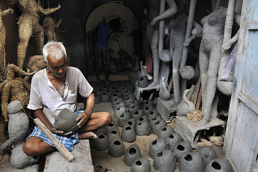 11th august 2014 kolkata west bengal india:Artisan making clay idols of Goddess Durga before Durga Puja Festival Kumartuli Kolkata West Bengal India