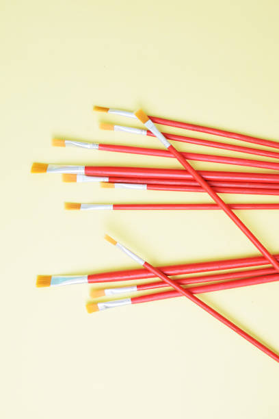 istock Set of paint brushes on yellow background 1265638752