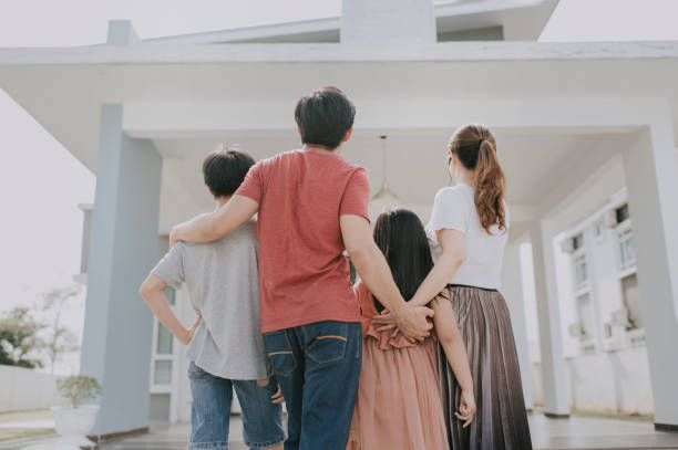 una famiglia cinese asiatica che si trasferisce in una nuova casa ammirando la loro casa - domestic life young family family child foto e immagini stock