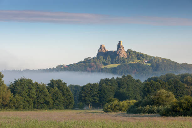 ruiny starego zamku trosky w czeskim raju, czechy. ruiny składają się z dwóch zwięzłych wież na drzewnym wzgórzu. poranny krajobraz z mglistą atmosferą - architecture blue bohemia built structure zdjęcia i obrazy z banku zdjęć