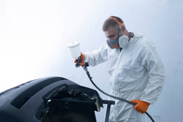 Painting the bumper of the car in the spray booth. Car mechanic at work. Painting the bumper of the car in the spray booth. Car mechanic at work. door panel stock pictures, royalty-free photos & images