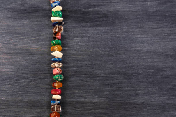 beads made of ural minerals and gems on wooden background with empty space for text