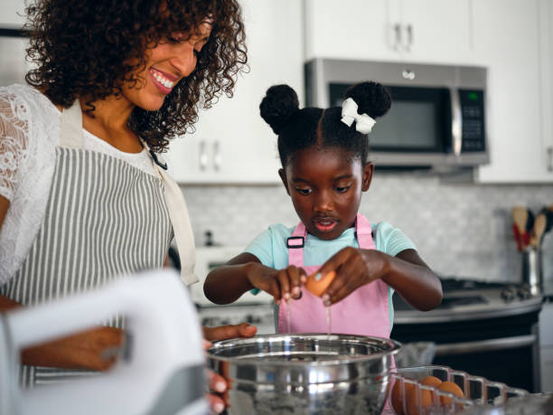 istock Mother and Daughter Baking Cupcakes in a Home Kitchen 1265651378