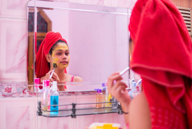 istock Beautiful girl applying yellow turmeric face pack on face. 1265651506