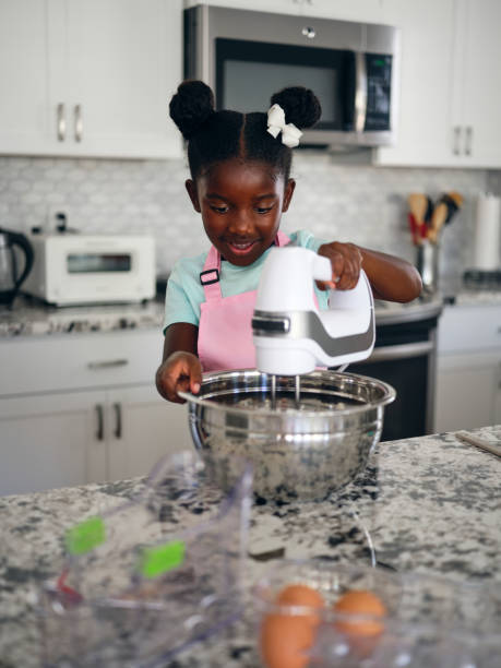 istock Little Girl Baking Cupcakes in a Home Kitchen 1265651711