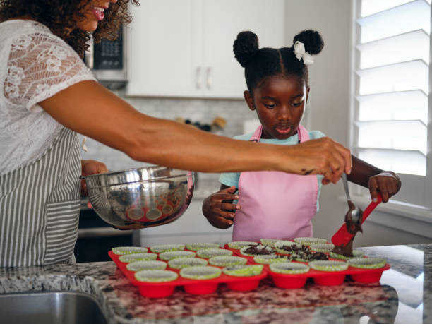 istock Mother and Daughter Baking Cupcakes in a Home Kitchen 1265653177