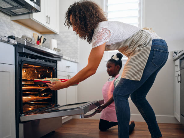 istock Mother and Daughter Baking Cupcakes in a Home Kitchen 1265653386