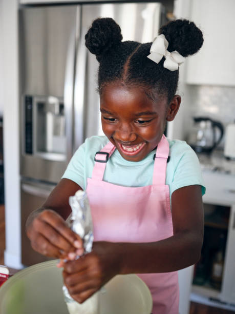 istock Little Girl Baking Cupcakes in a Home Kitchen 1265653442