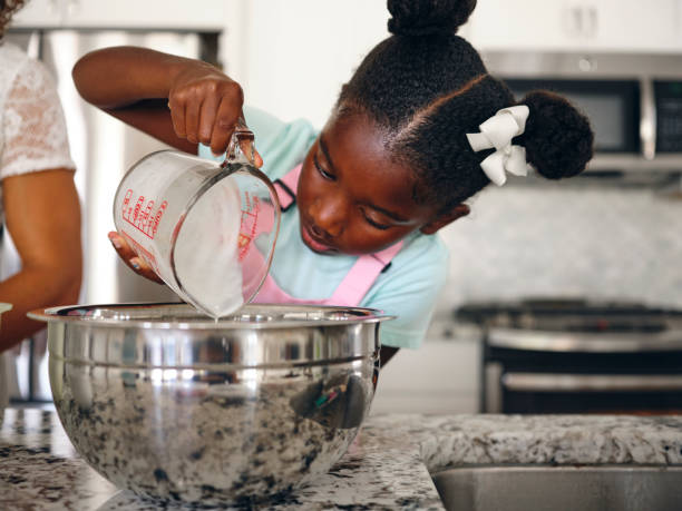 istock Mother and Daughter Baking Cupcakes in a Home Kitchen 1265653606