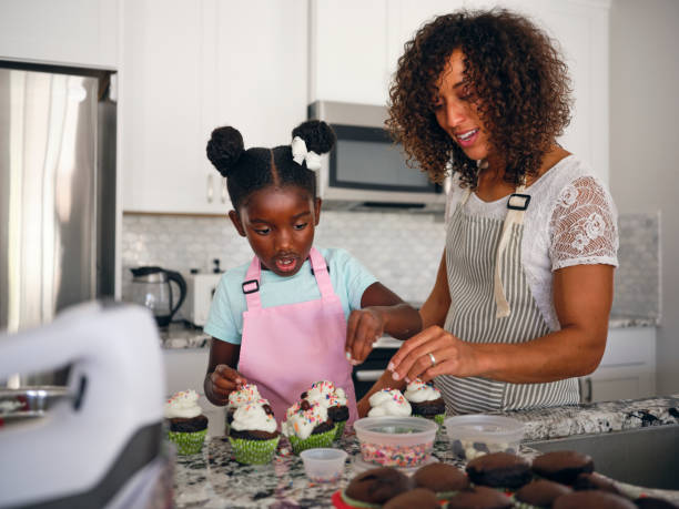 istock Mother and Daughter Baking Cupcakes in a Home Kitchen 1265655065