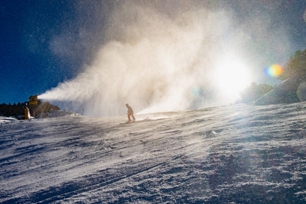 istock People downhill skiing below working snow canon 1265655808