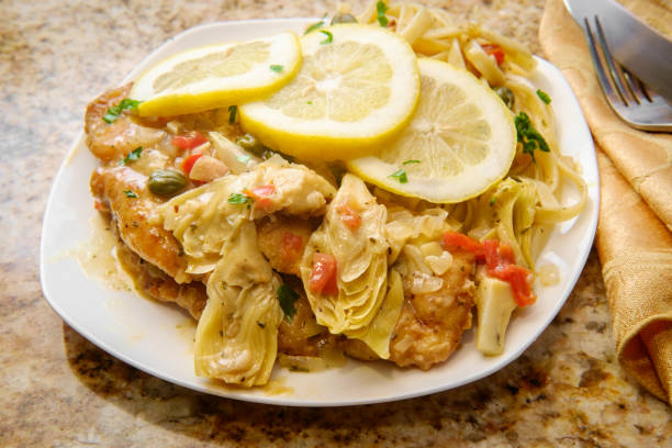 Chicken Piccata Linguine Italian chicken piccata schnitzel with artichoke hearts served on fettuccine Artichoke stock pictures, royalty-free photos & images