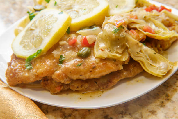 Chicken Piccata Linguine Italian chicken piccata schnitzel with artichoke hearts served on fettuccine scaloppini stock pictures, royalty-free photos & images