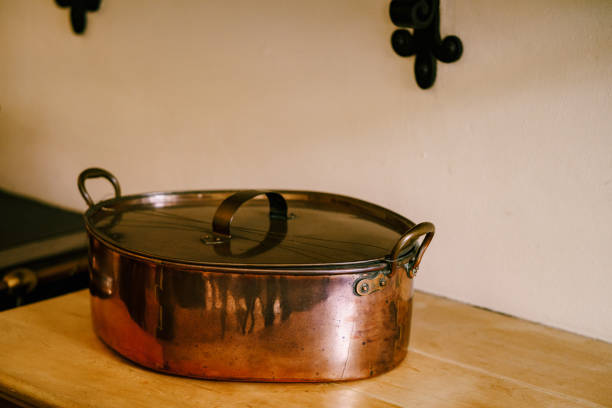 istock Close-up of a large saucepan on a wooden tabletop against a whitewashed wall. 1265669809