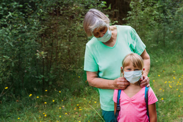 istock grandmother put mask on child before going to school 1265670353