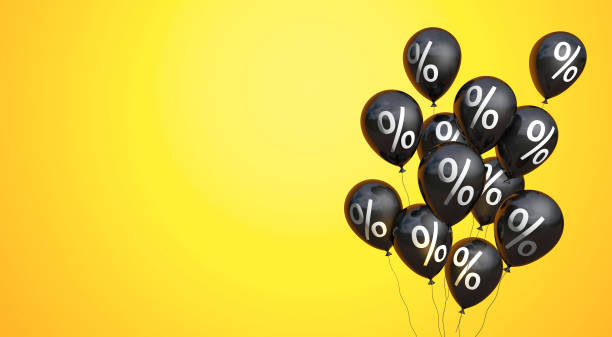 istock Black Friday. Black balloons with a percent symbol on yellow background. Copy space for text 1265671447