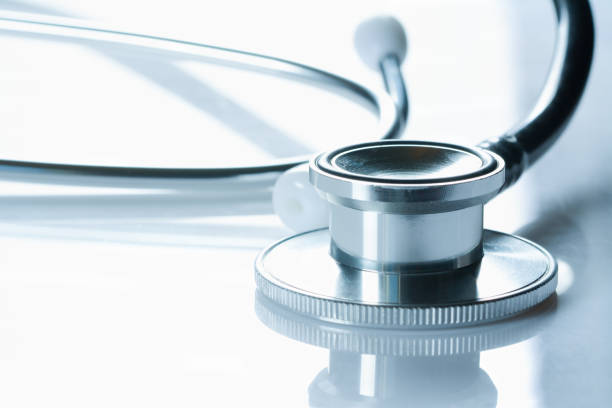 istock Stethoscope on glossy white table, the black phonendoscope, close up on white background, 1265671463