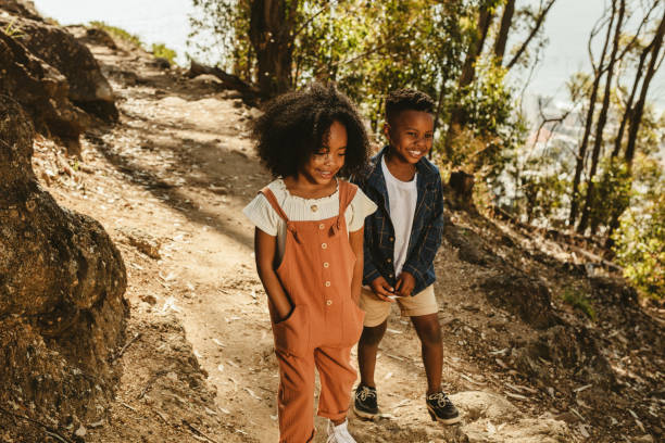 istock Cute boy and girl walking on a mountain trail 1265671646
