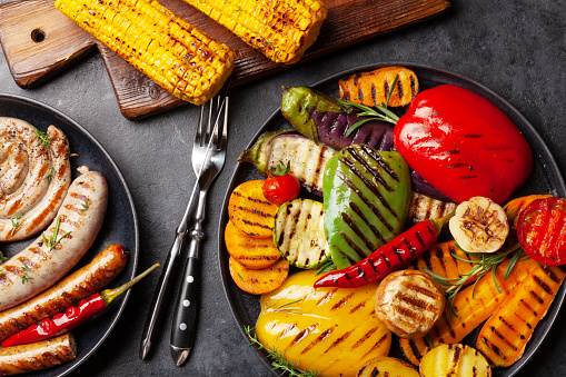 Grilled sausages and vegetables with spices and herbs. Top view flat lay