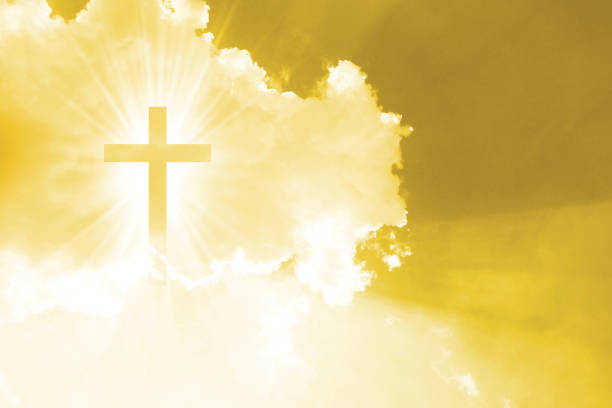 istock Christian cross appears bright in the yellow sky 1265674152