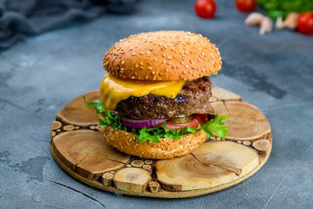 istock Burger with meat cheese and bacon on grey concrete table 1265679753