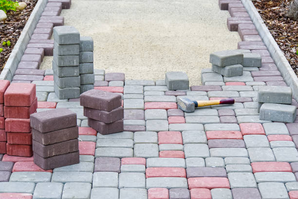 istock worker laying paving stones. stone pavement, construction worker laying cobblestone rocks on sand. 1265682610