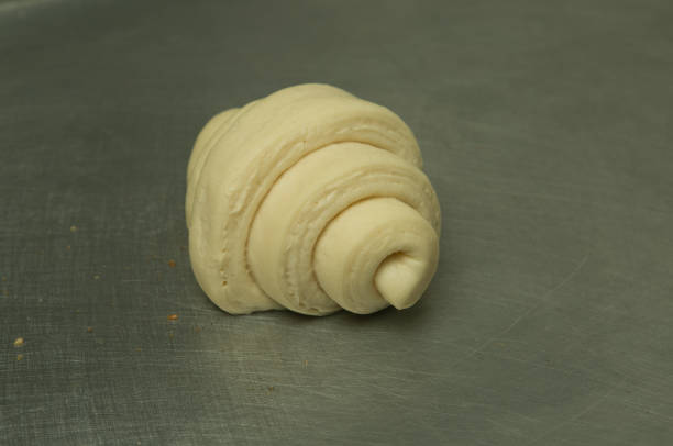 istock Croissant making process. Croissants ready to bake are on the table. 1265682745