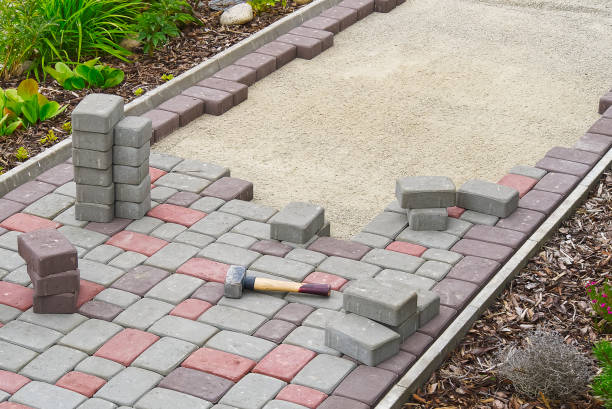 lavoratore posa pietre pavimentazione. pavimentazione in pietra, operaio edile che posa rocce di ciottoli sulla sabbia. - grouting foto e immagini stock