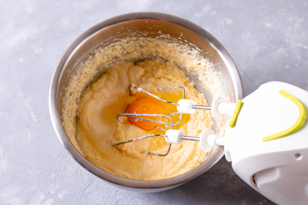 istock Mixing butter with sugar and eggs in bowl 1265683399