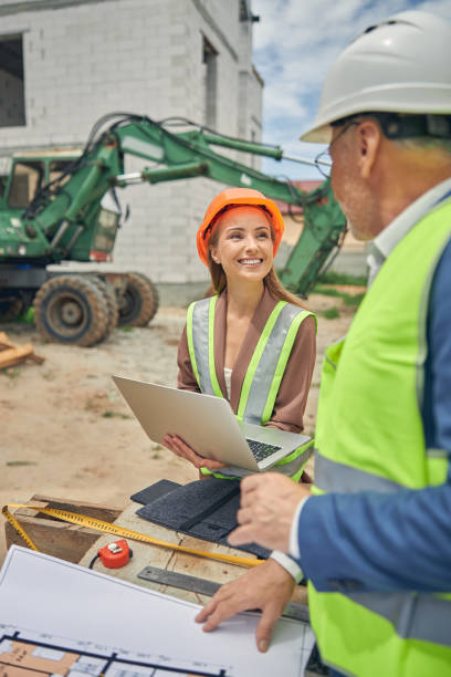 istock Woman in a hard hat communicating with her colleague 1265683552