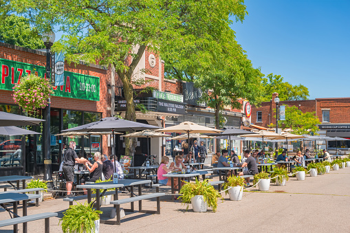 People eat outdoors on restaurant patios in Hamilton, Ontario, Canada on a sunny day.