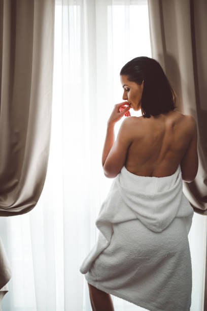 istock Young bareback woman looking through the window 1265688288