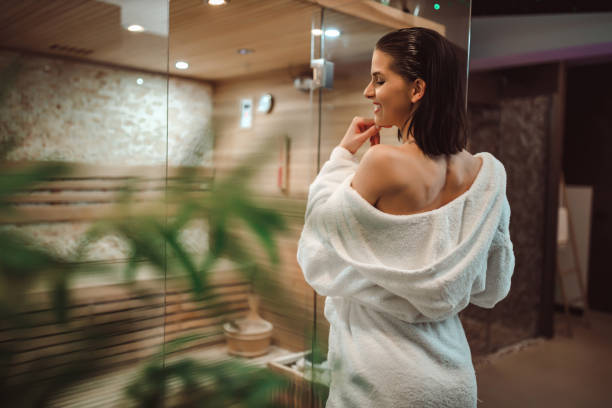 istock Young woman in a bathrobe entering sauna 1265688312