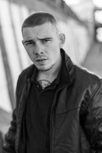 istock Bully criminal in black leather jacket. Black and white photo 1265688456